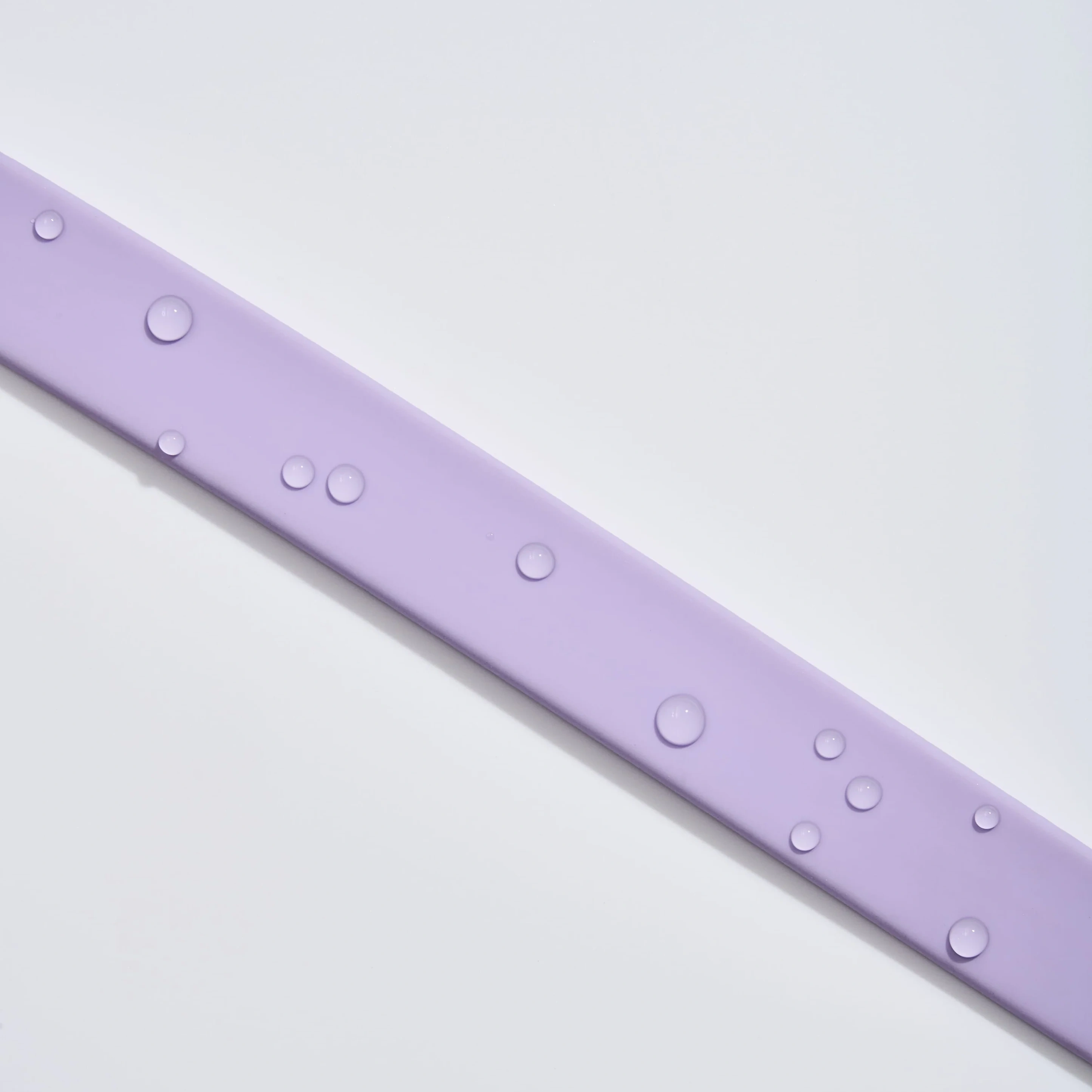 Water droplets beading on the surface of a purple MoonianPet waterproof coated webbing leash — non-porous PVC surface repels water instead of absorbing it, making cleaning effortless