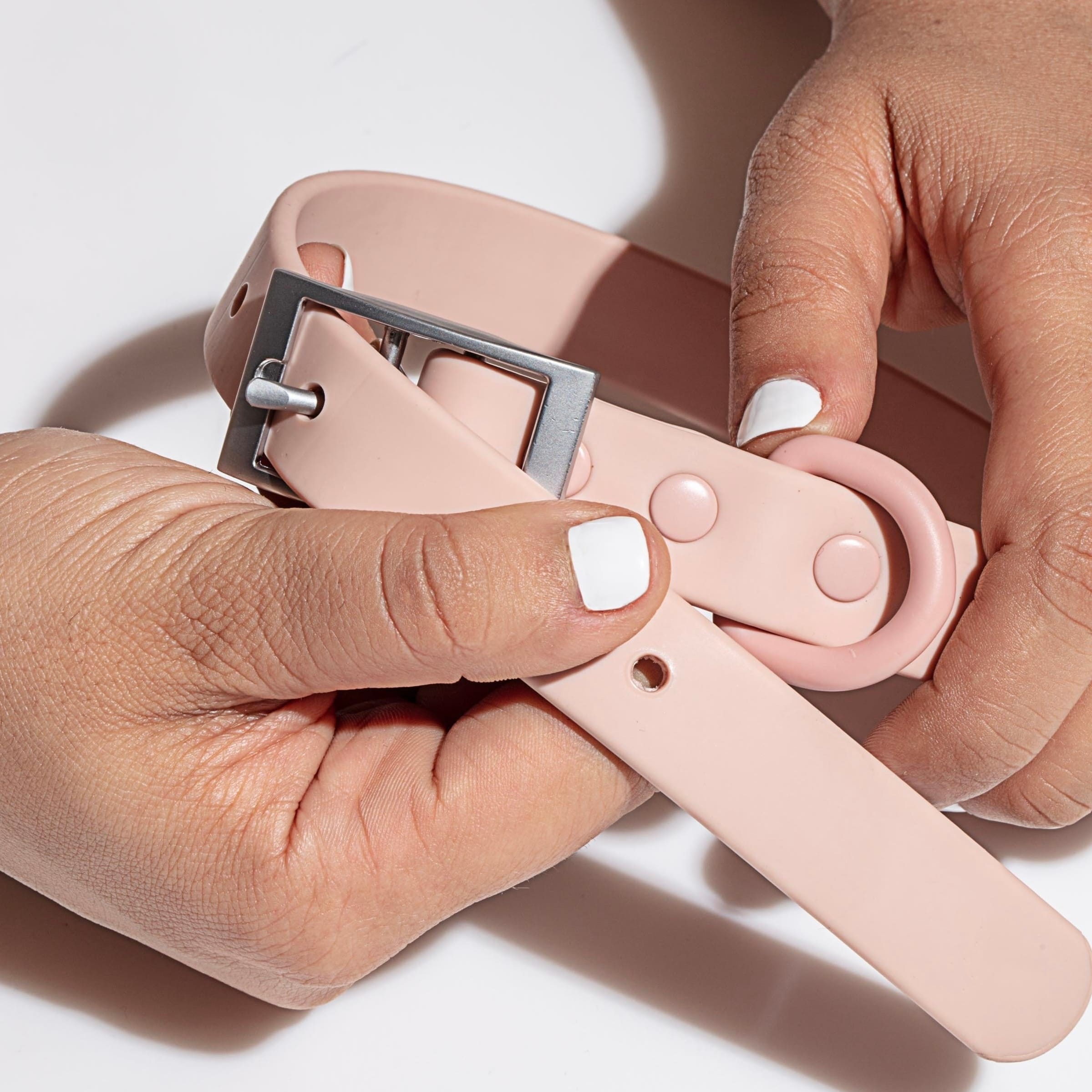 MoonianPet waterproof dog collar in pink — hand holding collar showing flexible coated webbing material