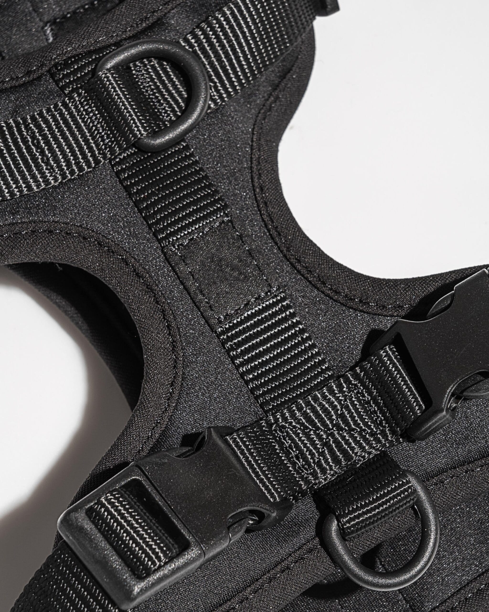 Close-up of black MoonianPet harness buckle hardware — smooth surface that wipes clean easily without absorbing dirt